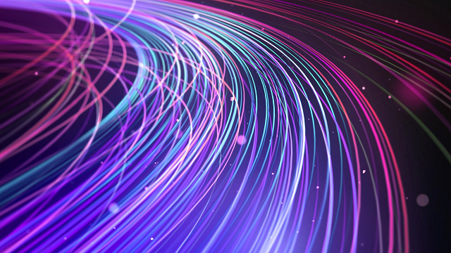 Stock image of fibre optic cables illuminated blue, pink and purple against a dark background.